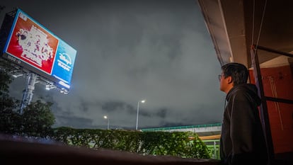 Edson Moysen en el balcón de su departamento, mira el espectacular de la empresa JCDecaux, en Ciudad de México, el 20 de junio 2025.