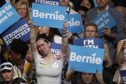 Una seguidora de Bernie Sanders sujeta, decepcionada, la pancarta con el nombre del senador durante la Convención Nacional Demócrata en Filadelfia, Pensilvania, EEUU.