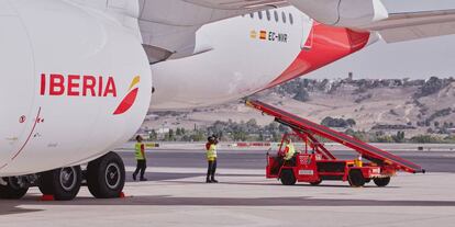 Personal de Iberia presta servicios en tierra a uno de los aviones de la compañía.