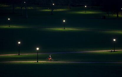 Un ciclista en un camino del Primrose Hill de Londres durante el atardecer.