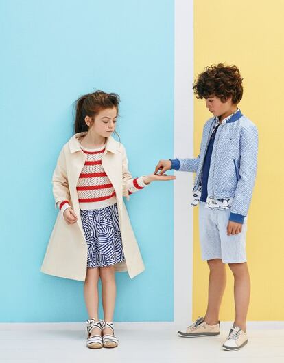 Arrieta lleva abrigo de loneta de Little Creative Factory, jersey de punto calado con rayas rojas y blancas de Pepe Jeans, falda azul y blanca con estampado geométrico de Lacoste y alpargatas de rayas de Gocco. Rodrigo viste una cazadora tipo ‘bomber’ con estampado geométrico de Tommy Hilfiger, camisa blanca con estampado de peces de Mayoral, bermudas milrayas de Hackett y deportivas color beis de Camper.