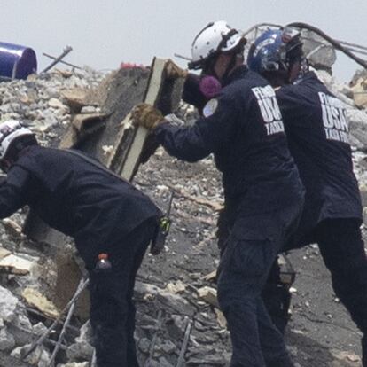 SURFSIDE, FLORIDA - JUNE 26: Members of the South Florida Urban Search and Rescue team look for possible survivors in the partially collapsed 12-story Champlain Towers South condo building on June 26, 2021 in Surfside, Florida. Over 150 people are being reported as missing as search-and-rescue efforts continue with rescue crews from across Miami-Dade and Broward counties.   Joe Raedle/Getty Images/AFP
== FOR NEWSPAPERS, INTERNET, TELCOS & TELEVISION USE ONLY ==