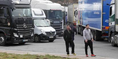 Dos camioneros y varios camiones estacionados en la explanada de acceso a Pedrafita do Cebreiro.