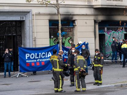 Un grupo de bomberos conversa delante de la oficina bancaria ocupada en la plaza Tetúan cuyo incendio causó cuatro víctimas mortales.