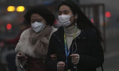 Dos mujeres caminan por las calles de Pekín (China) hoy, 1 de diciembre de 2015. Pekín sigue en niveles máximos de contaminación.