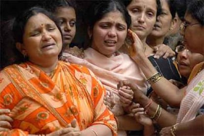 Familiares de una de las víctimas de los trenes de Bombay se despiden del cuerpo antes de la cremación.