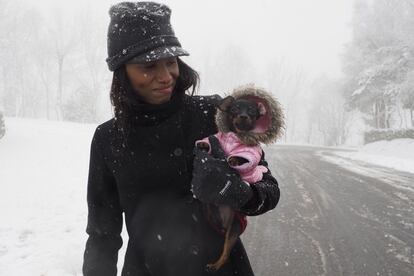 Una mujer y su mascota disfrutan de la nevada en O Cebreiro (Lugo) el 12 de enero de 2016.