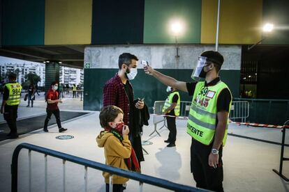 Un trabajador mide la temperatura a un hombre y a su hijo antes de que accedan al estadio José Alvalade de Lisboa para ver el encuentro amistoso de fútbol entre Portugal y España la semana pasada.