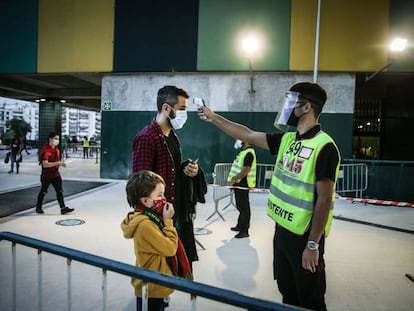 Un trabajador mide la temperatura a un hombre y a su hijo antes de que accedan al estadio José Alvalade de Lisboa para ver el encuentro amistoso de fútbol entre Portugal y España la semana pasada.