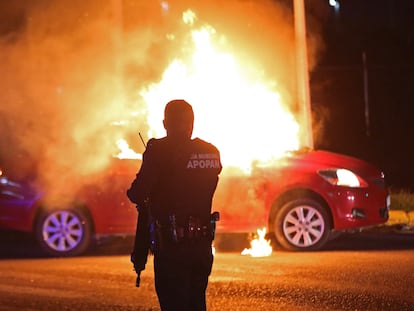 Un policía municipal de Zapopan acude al lugar donde grupos delincuenciales habían incendiado un vehículo, en el Estado de Jalisco