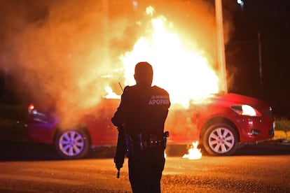 Un policía municipal de Zapopan acude al lugar donde grupos delincuenciales habían incendiado un vehículo, en el Estado de Jalisco