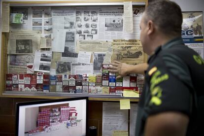 Un agente del grupo Fiscal y Fronteras de la guardia civil del Puerto de Santa María en Cádiz, junto a varias muestras de tabaco ilegal incautado y noticias sobre sus operaciones
