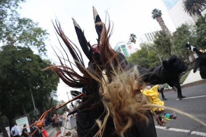 Un hombre con vestimenta tradicional baila sobre la avenida Paseo de la Reforma, en Ciudad de México.