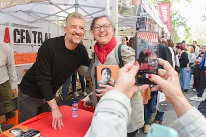 El periodista i escriptor Toni Cruanyes es fotografia amb una lectora i un dels seus exemplars el dia de San Jordi 2025, a Barcelona
