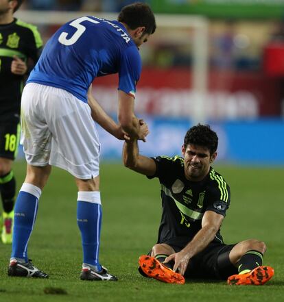Costa, sobre el césped, es ayudado por Motta tras recibir una falta.
