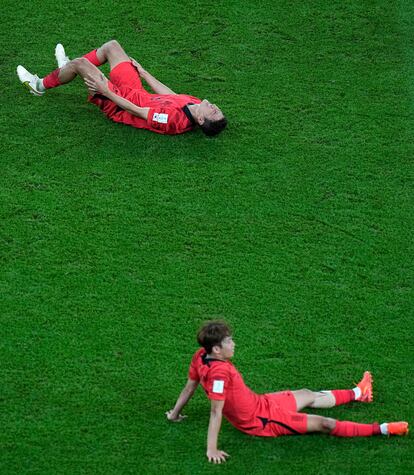 Dos jugadores coreanos tendidos en el suelo tras el encuentro frente a Uruguay.