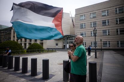 Un hombre y una mujer ondean una bandera palestina frente a la embajada estadounidense en Berlín, Alemania, el 15 de mayo de 2018. 