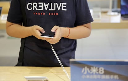 Un cliente prueba un teléfono de Xiaomi en una tienda.