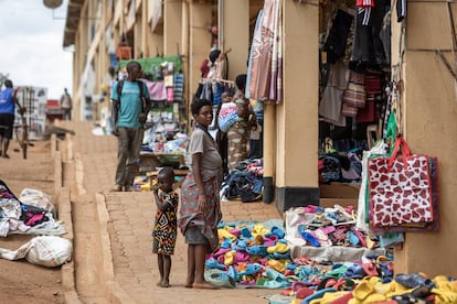 Una mujer ruandesa camina con su hija por el mercado de Mulindi, en Kigali, en junio de 2023.