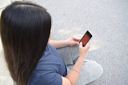 Una mujer usa su teléfono móvil. 