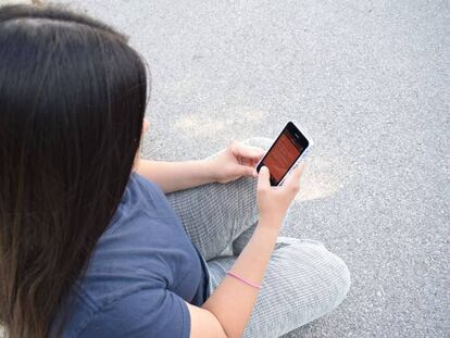 Una mujer usa su teléfono móvil. 