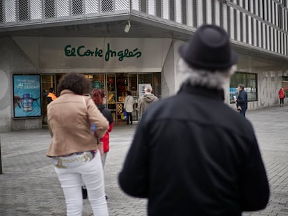 Varias personas hacen cola para entrar en El Corte Inglés en Pamplona.