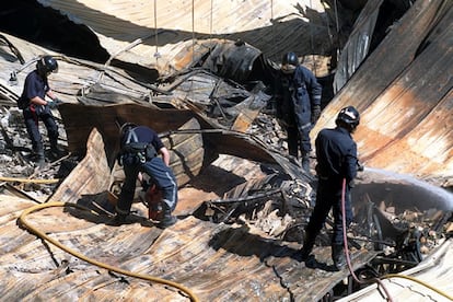 En la imagen, los bomberos intentando sofocar las últimas llamas entre los escombros del edificio.