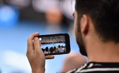 Un espectador graba en vídeo con su teléfono móvil la final del Open de Australia, el 28 de enero de 2018.