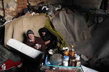 Dos hombres sin hogar se resguardan del frío en una factoría del barrio de Vysocany, en Praga.