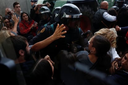 Oficials de la Guàrdia Civil s'obren pas a través d'una multitud cap a una mesa de votació a Sant Julià de Ramis.