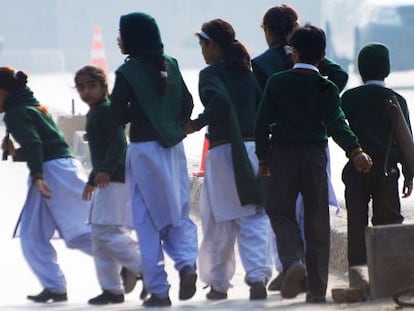Grupo de estudantes da escola atacada em Peshawar (Paquistão) se afasta do lugar do atentado.
