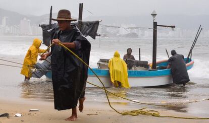 Varios pescadores sacan sus botes del agua como anticipación a la llegada del huracán Max en Acapulco (México).