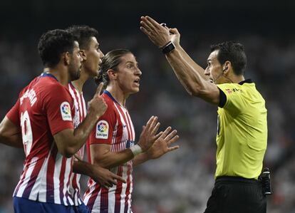 El arbitro es increpado por los jugadores del Atlético de Madrid.