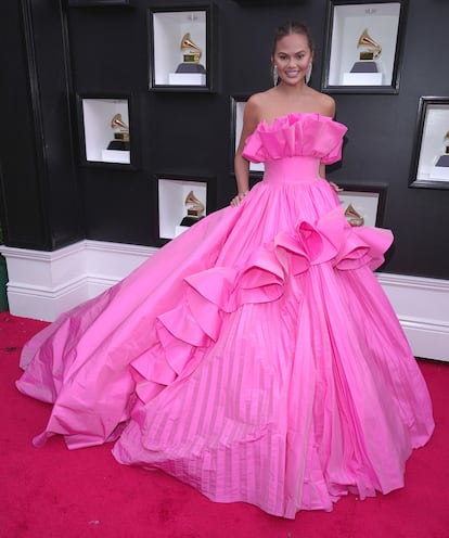 Chrissy teigen con un voluminoso vestido fucsia de volantes de Nicole+Felicia.