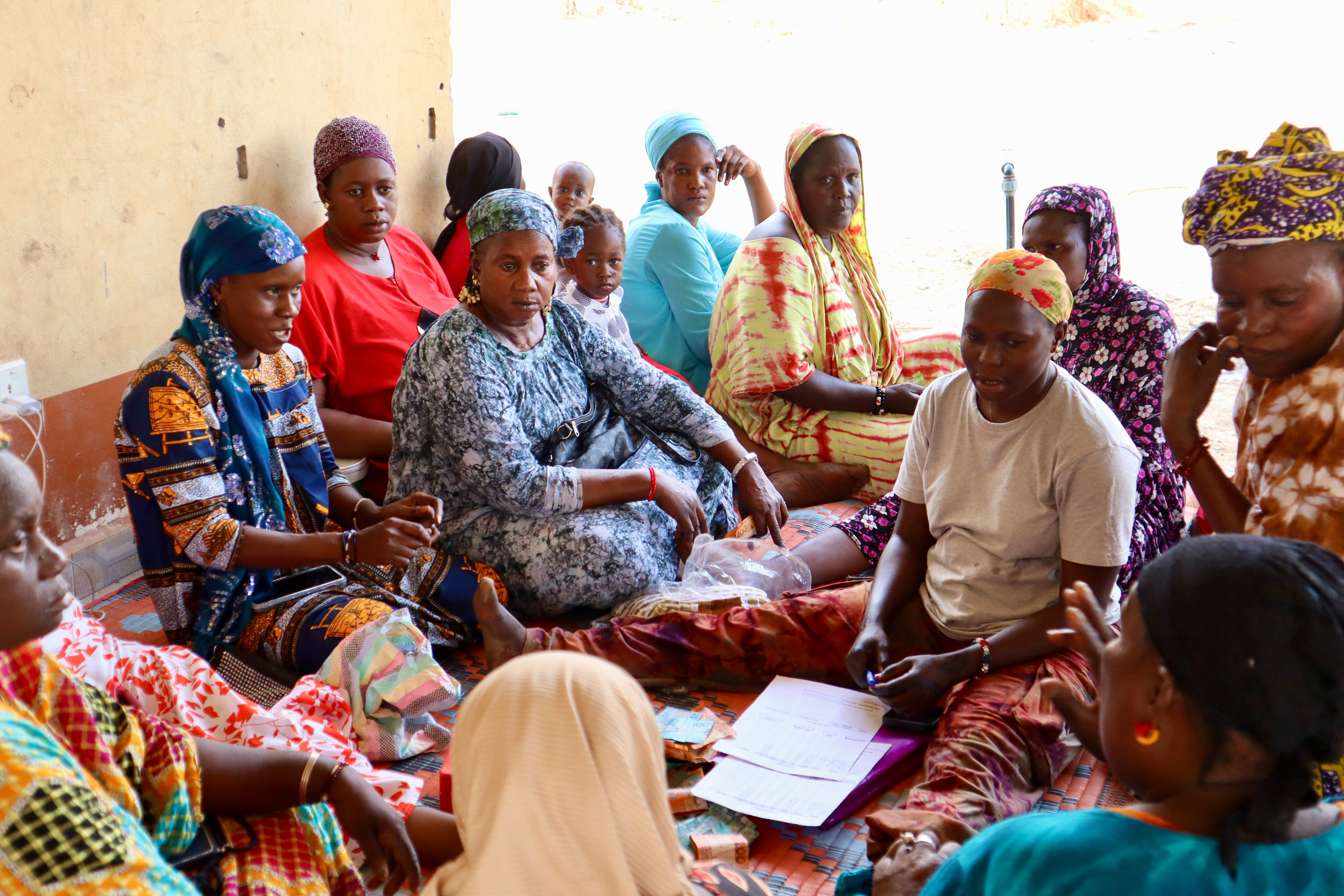 Fatou Njie reunida con las mujeres de Kudang Tenda, el 20 de mayo de 2025. La fabricación de hielo que facilita la Plataforma Solar Multifuncional les permite acceder a mercados a los que antes no podían llegar para vender el pescado que sus maridos sacan del río Gambia.