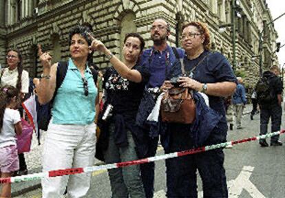 Un grupo de turistas españoles observa la crecida del río Moldava junto al Teatro Nacional de Praga.