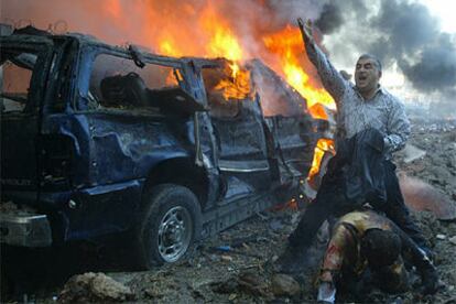 Un hombre grita pidiendo ayuda junto a uno de los coches afectados por la explosión en Beirut.