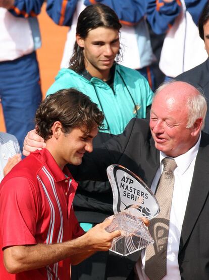 Federer (izquierda) recibe el trofeo de ganador del director del torneo Masters de Hamburgo, Walter Knapper, después de ganar en la final al español Nadal (atrás), en 2007.