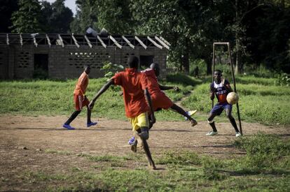 Adolescentes juegan al fútbol en Kaga Bandoro, una ciudad a 350 kilómetros de la capital centroafricana. Al fondo se puede ver la escuela de primaria, cuyo tejado e interior fueron destruidos durante un combate reciente. Es lo mismo que les ha ocurrido a muchos colegios del país, que han quedado inoperativas.