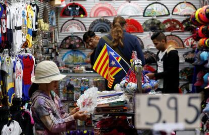 Turistas realizan compras en una tienda de souvenirs de Barcelona.