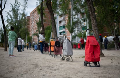 Vecinos a la espera de que una entidad vecinal les entregue alimentos, el sábado en Madrid.