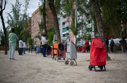 Vecinos a la espera de que les entreguen alimentos en la Asociación de Vecinos de Aluche.