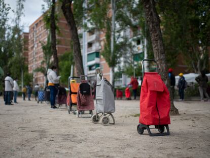 Vecinos a la espera de que una entidad vecinal les entregue alimentos, el sábado en Madrid.