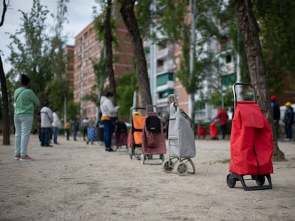 Vecinos a la espera de que les entreguen alimentos en la Asociación de Vecinos de Aluche.