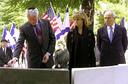 Bill Clinton visita la tumba de Isaac Rabin en Jerusalén, junto a Dalia Rabin y Simón Peres (derecha).