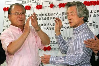 Koizumi (derecha) y el secretario general del Partido Liberal Democrático celebran su victoria ayer en Tokio.