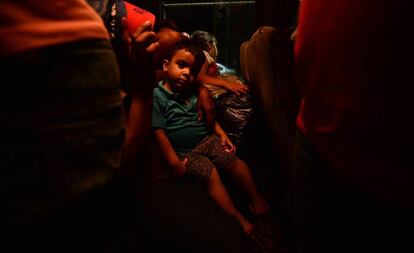 Tanto las autoridades como la Cruz Roja han estimado que más de 800 personas se han unido a esta nueva caravana. Algunos comenzaban a partir apiñados en microbuses. En la imagen, un niño hondureño viaja junto a su madre en un autobús que parte desde San Pedro de Sula hacia la frontera con Guatemala, el 9 de abril de 2019.