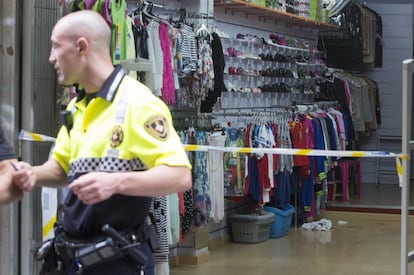Uno de los agentes de la Guardia Urbana sale de la tienda de 'souvenirs' en la que se resguardó uno de los heridos tras el tiroteo.