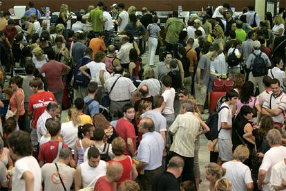 Miles de personas siguen esperando hoy en el aeropuerto de El Prat (Barcelona) para facturar sus maletas.