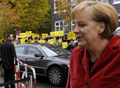 Manifestantes antinucleares protestan a la llegada de Merkel a la sede de las negociaciones de gobierno.